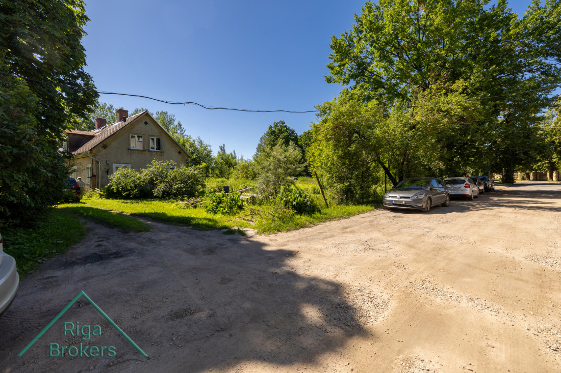 Back of the building with a garden and cars