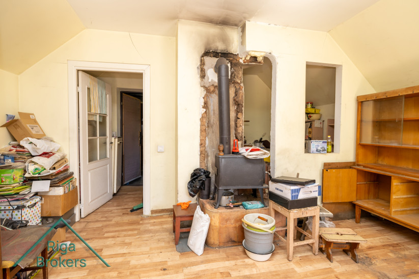 Room with a stove and worn-out furniture.