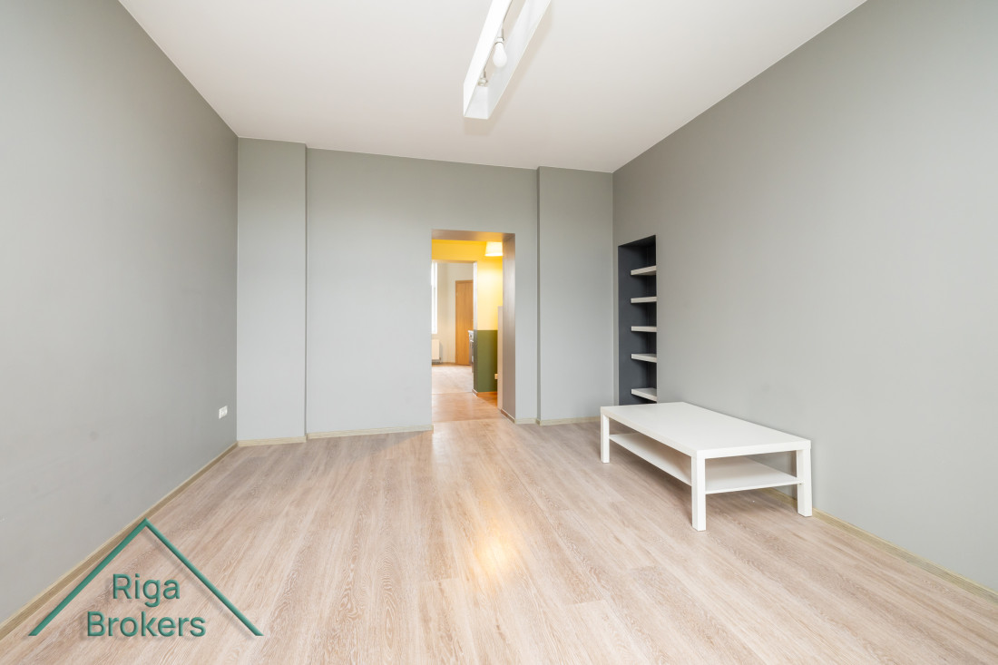  Spacious room with gray walls and a shelf.
