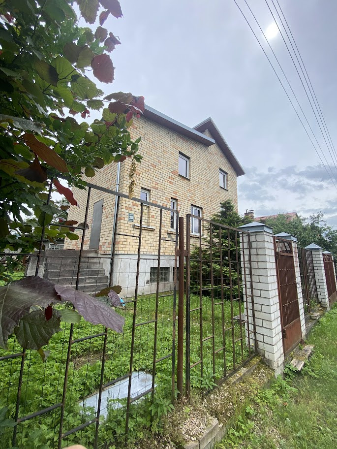 Brick house with metal fence in front.