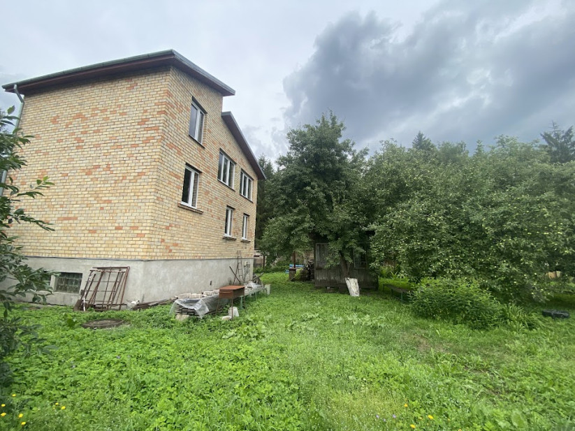 Rear view of a two-story brick house with garden