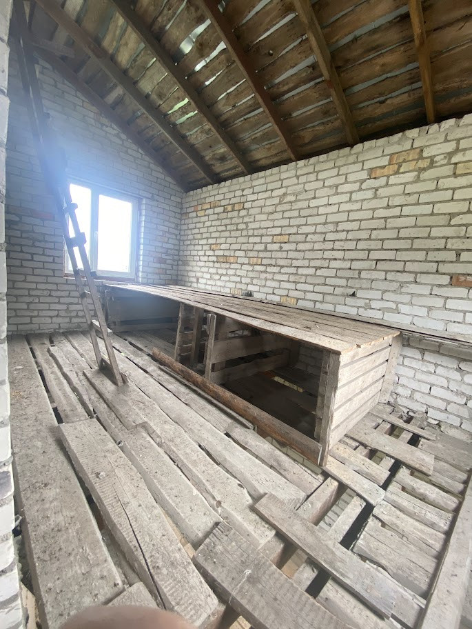 Attic space with wooden shelves and ladder.