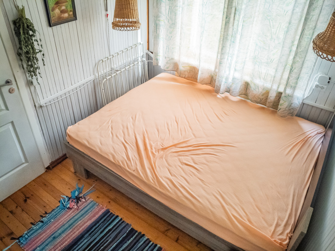 Gaiša guļamistaba ar oranžu gultu