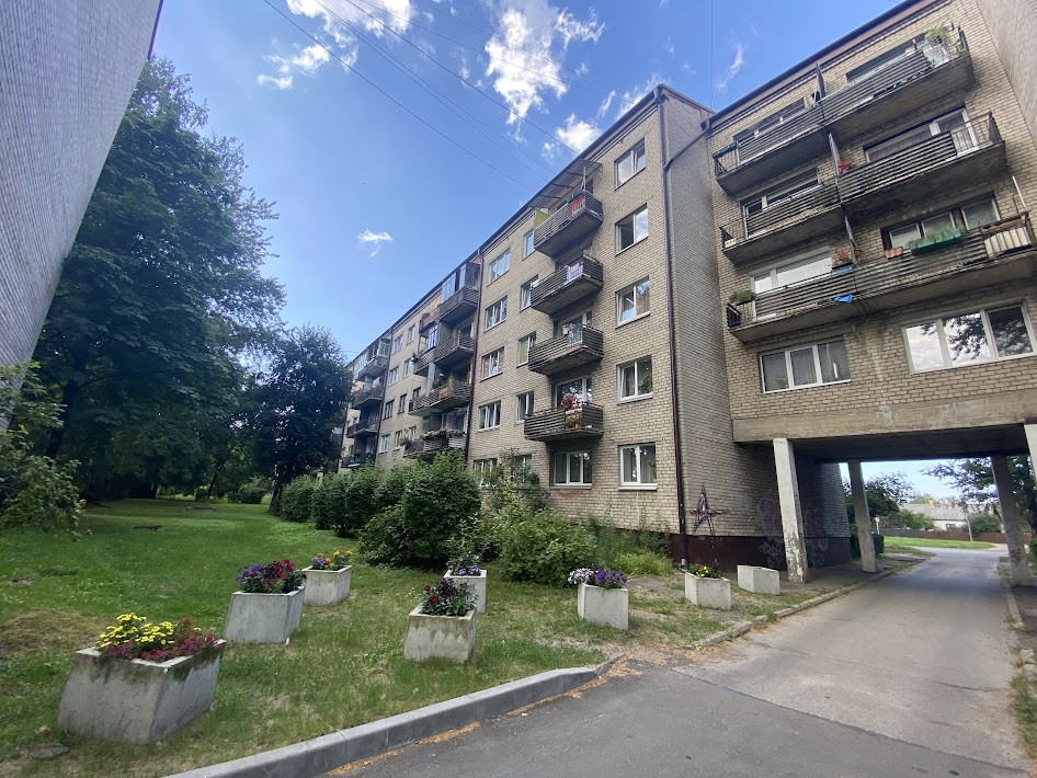 Multi-storey building with greenery and flower pots.