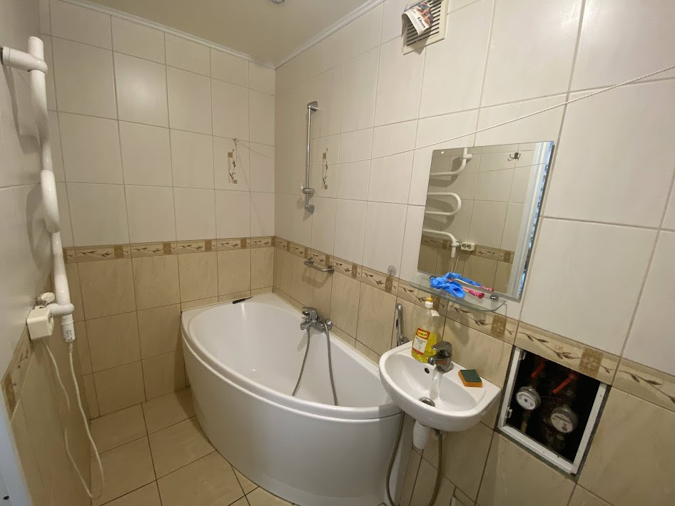 Bathroom with a round bathtub and tiling.