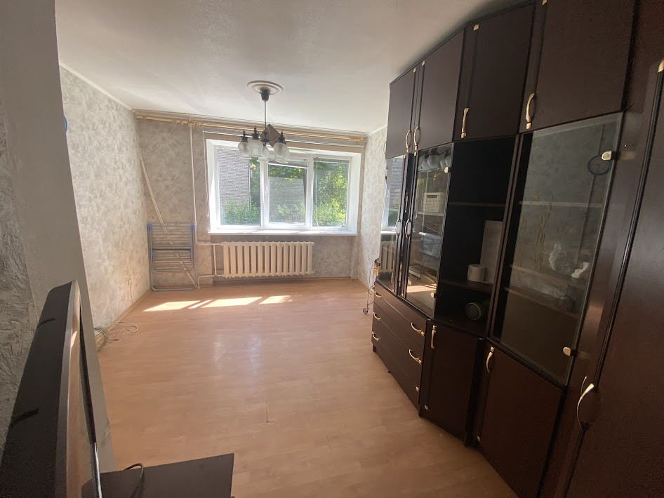 Living room with a large window and wall cabinets.