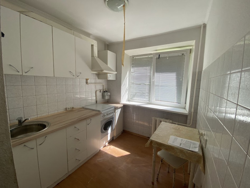 Kitchen with a white furniture set and a washing machine.
