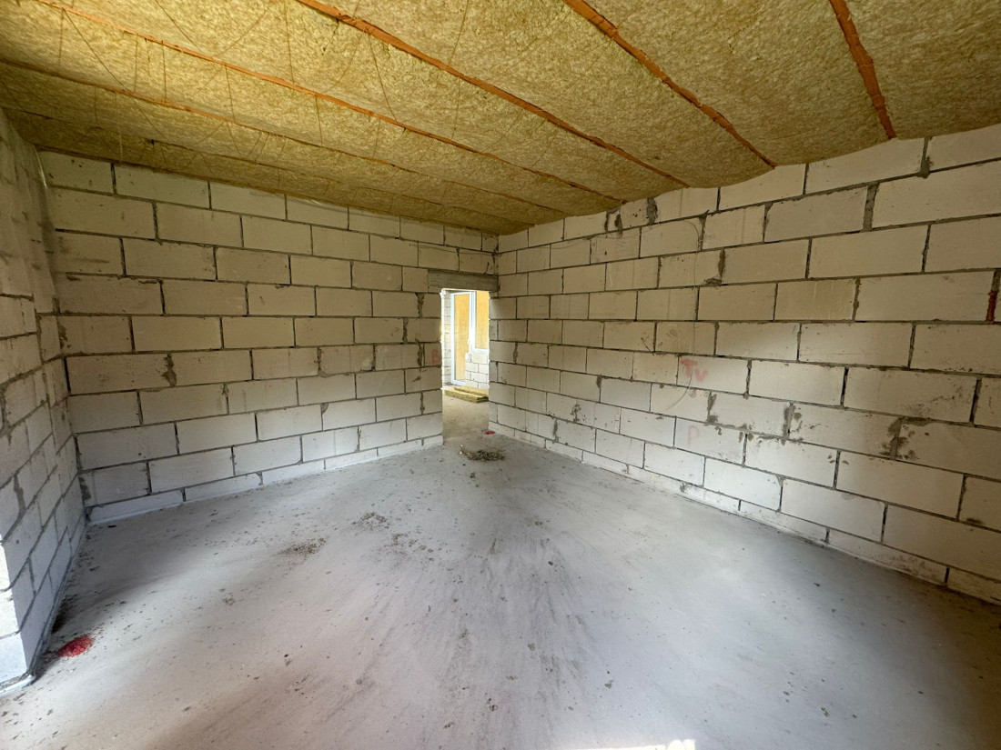 Plaša istaba ar mūra sienām un atvērtu logu.