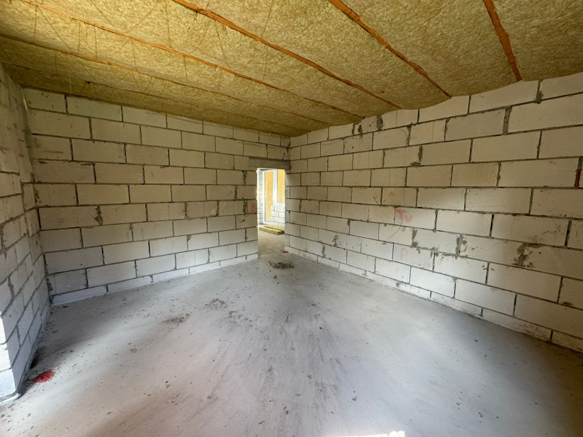 Plaša istaba ar mūra sienām un atvērtu logu.