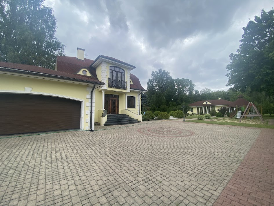 Māja ar piebūvi un bērnu rotaļu laukumu.