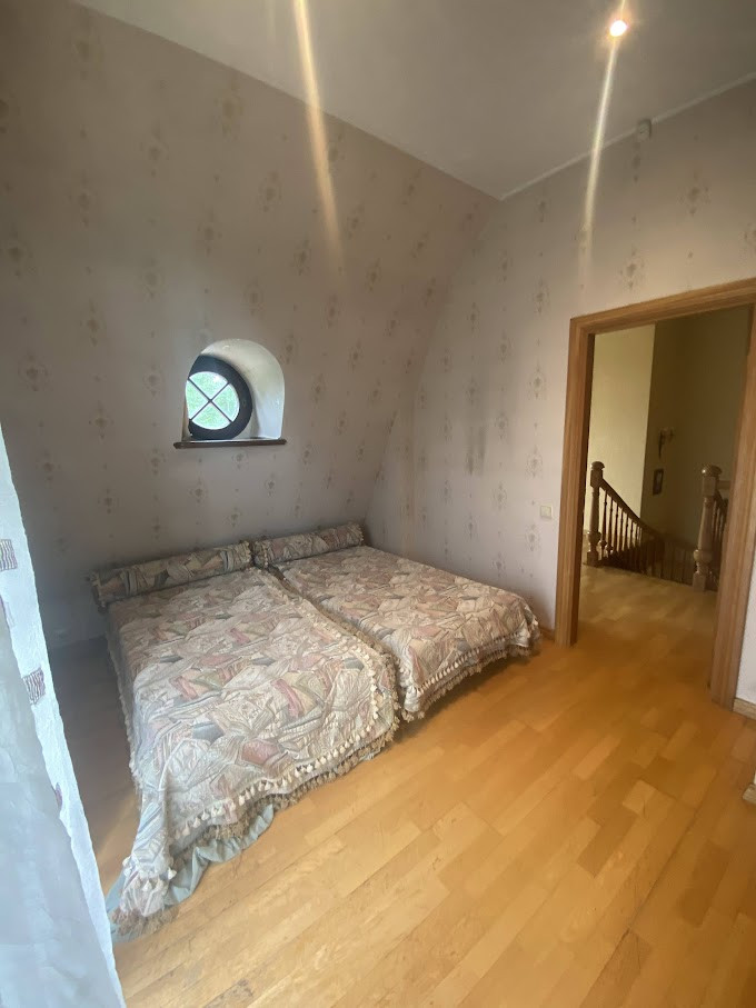 Divvietīga guļamistaba ar noapaļotu logu.