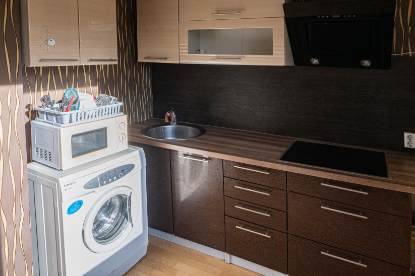 Virtuvē ir arī virtuves iekārta, elektriskā plīts, izlietne, veļas mašīna un mikroviļņu krāsns 