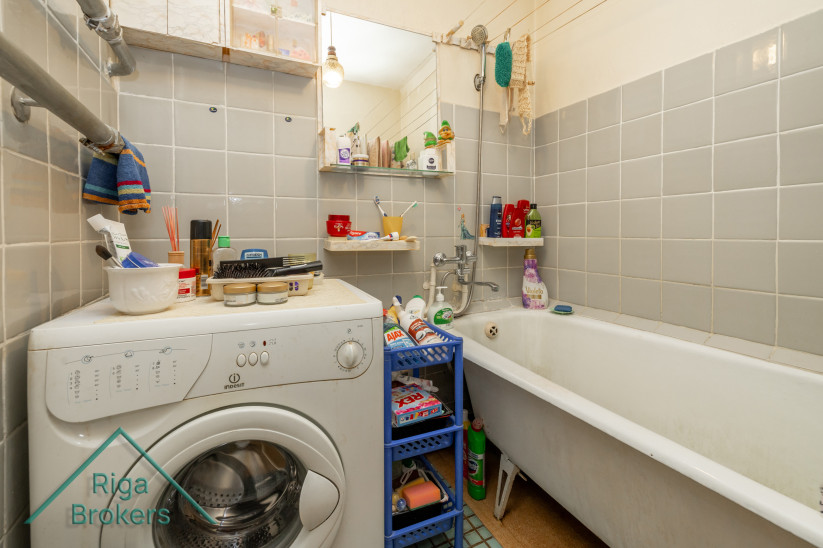 Bathroom interior with a bathtub and washing machine.