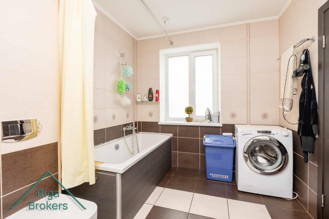 Bathroom with washing machine and bathtub.