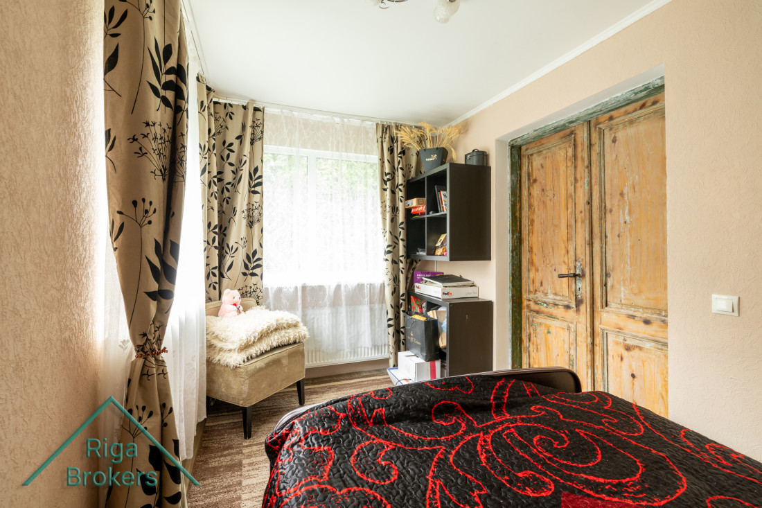 Bedroom with patterned curtains and bed.