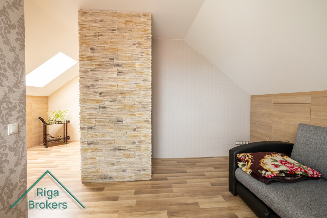 Living room with decorative wall and skylight.