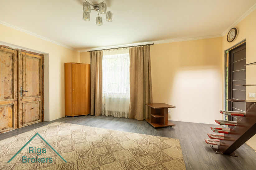 Large room with parquet floor and light curtains.
