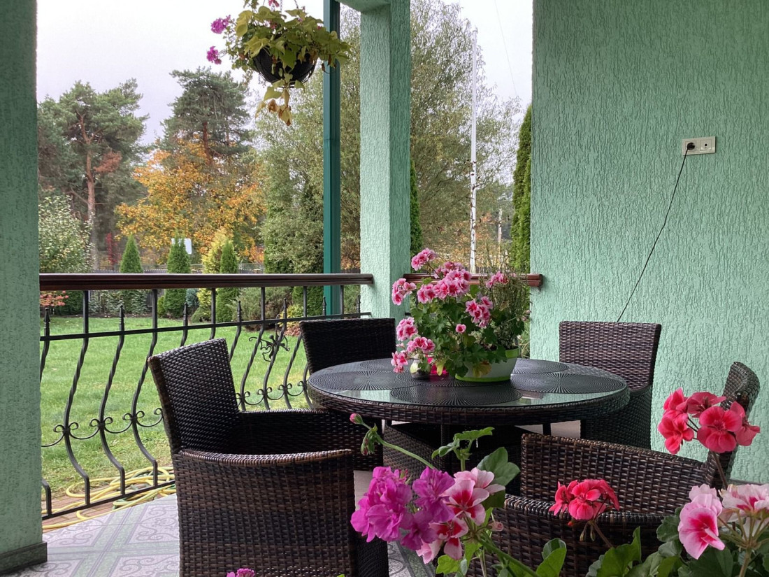 Flower decorations on terrace with garden view.
