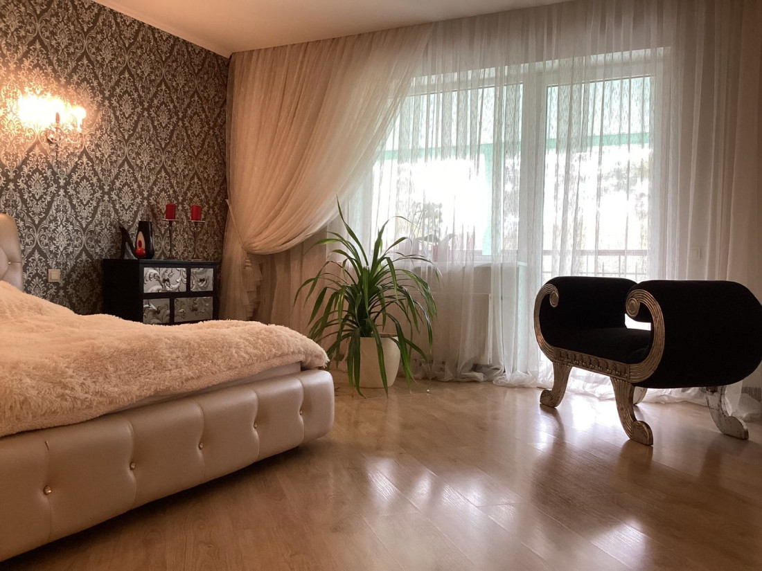 Bright bedroom with flowing curtains.