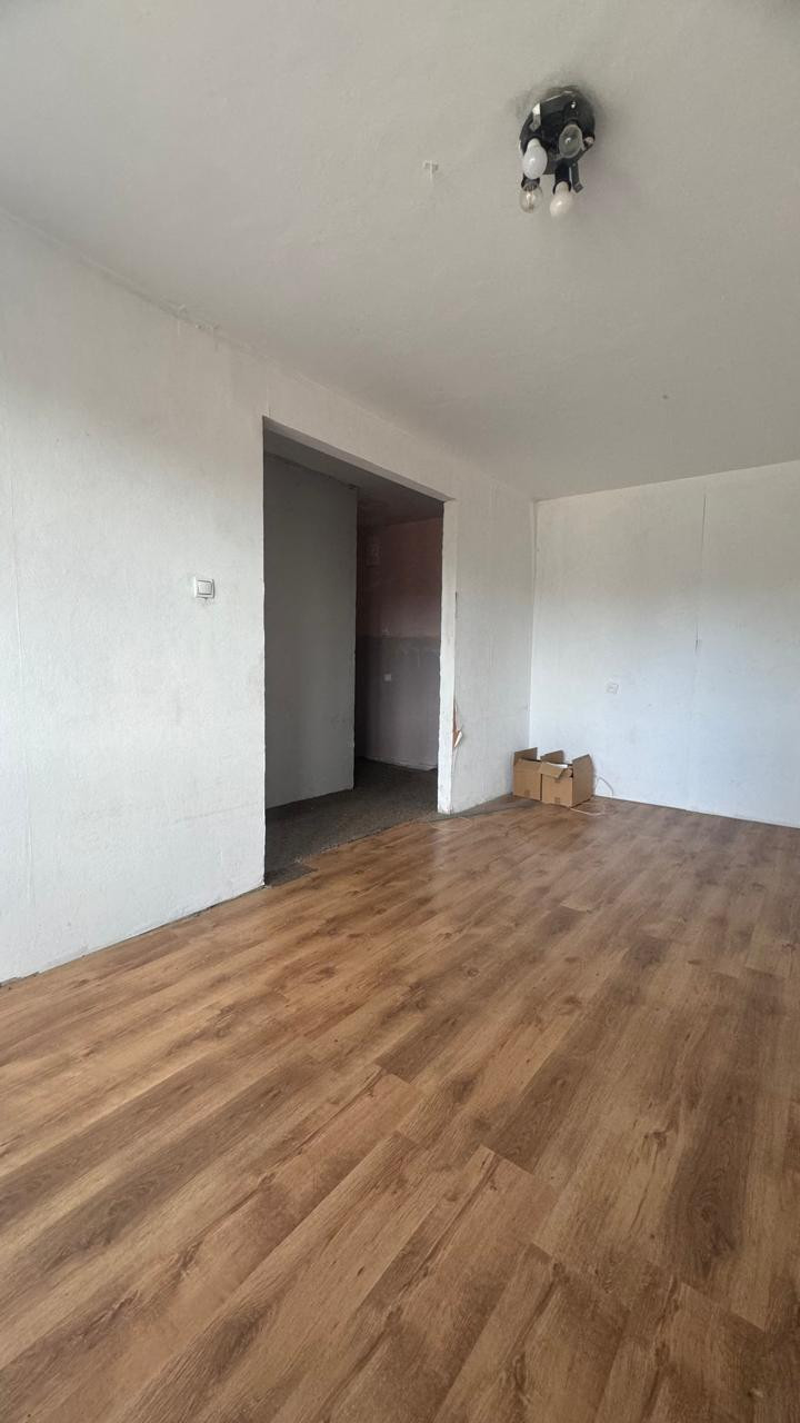 Istaba ar gaišu lamināta grīdu.