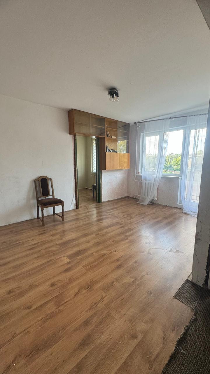 Dzīvojamā istaba ar grāmatu plauktu.