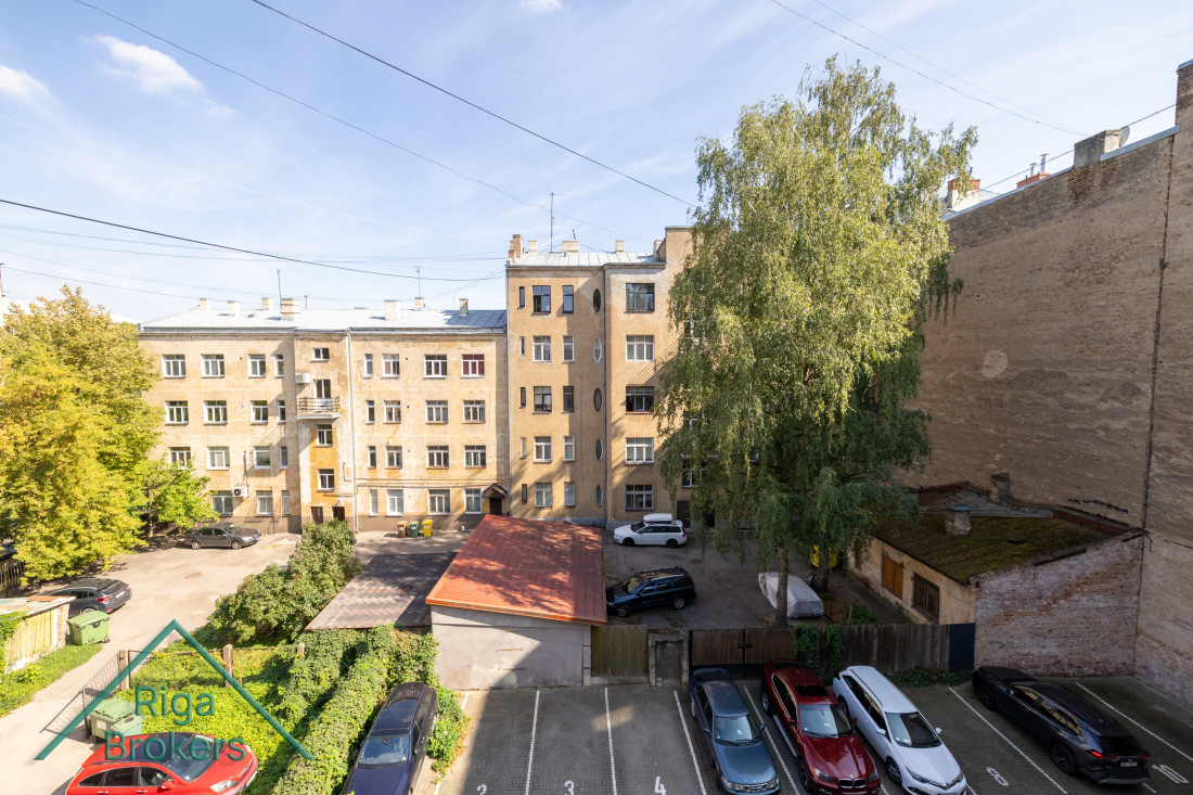 Двор с парковкой и деревьями.
