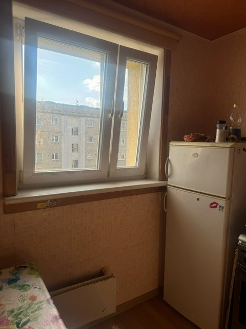 Kitchen with window and fridge.