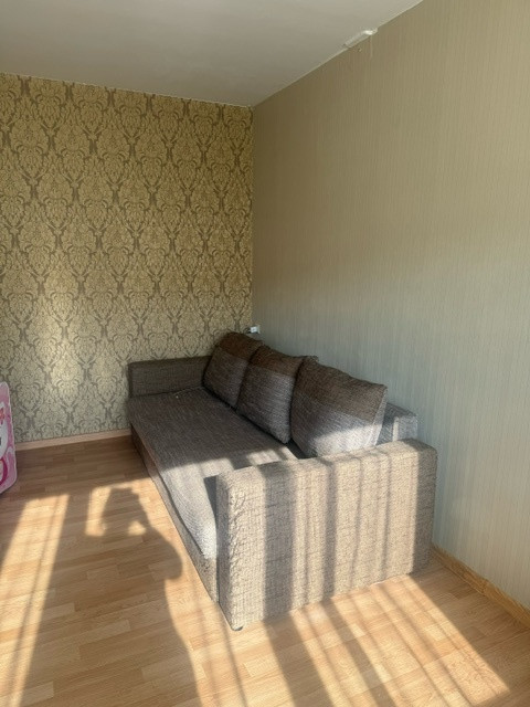 Living room with sofa and wallpaper.