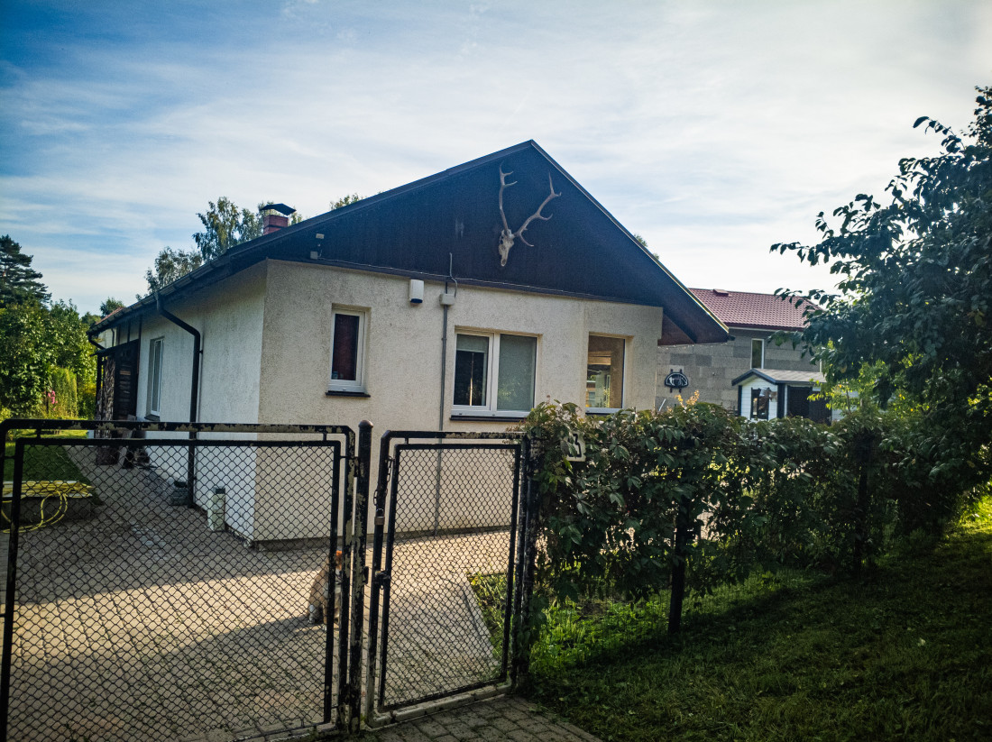 Māja ar vārtiem un brieža ragiem uz fasādes.