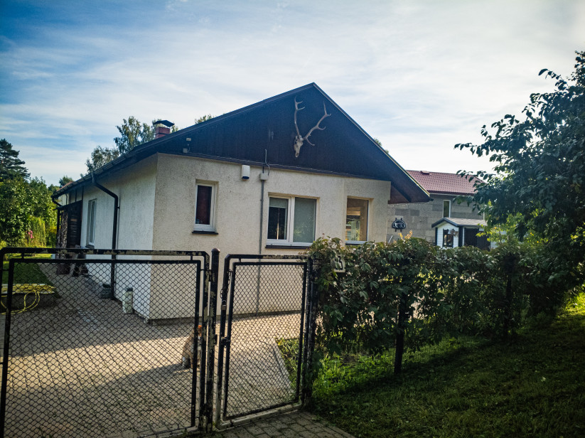 Māja ar vārtiem un brieža ragiem uz fasādes.