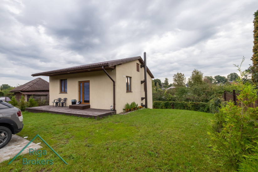 Privātmājas skats ar zaļu zālienu.