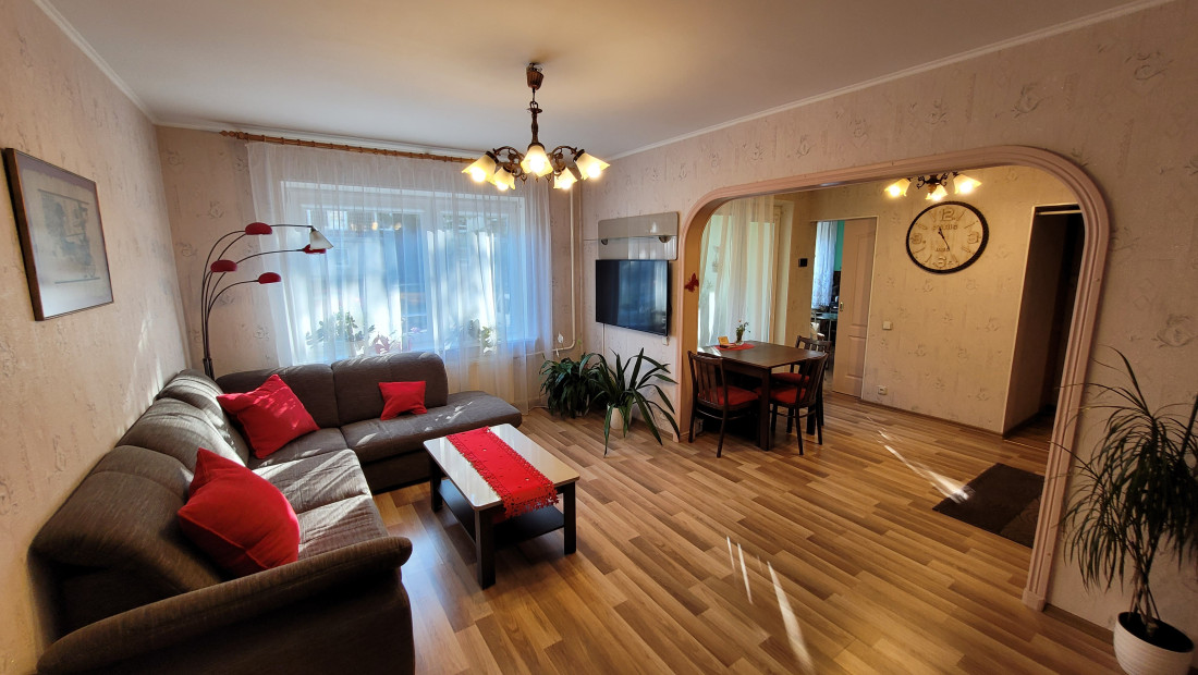 Living room with a large window and dining area.