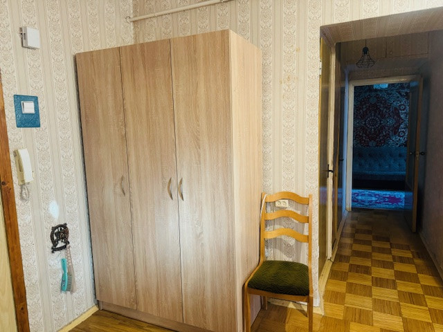 Koridors ar skapi un krēslu.