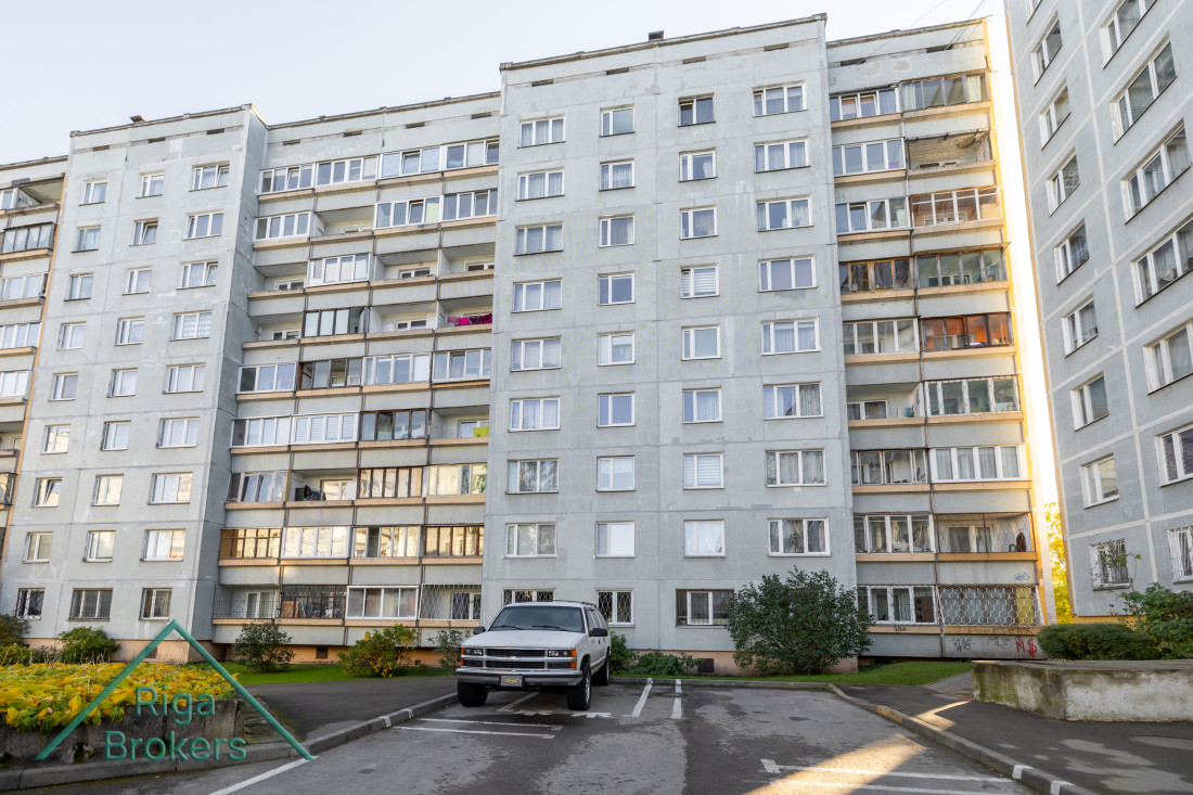 Daudzdzīvokļu ēka ar stiklotajiem balkoniem.