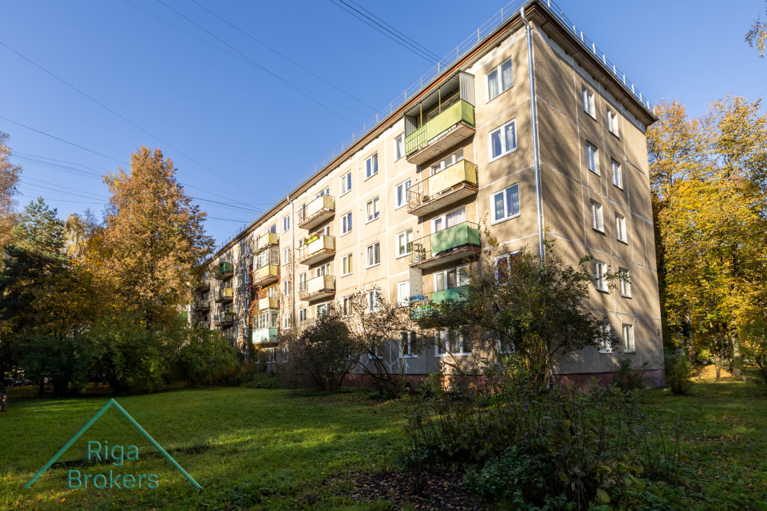 Five-story building with green balconies.