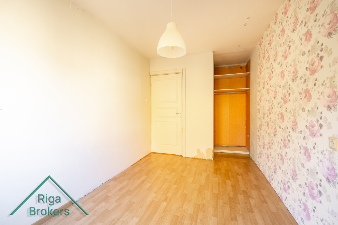 Room with a closet and ceiling lamp.