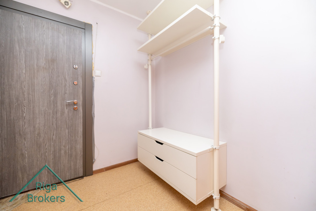 Hallway with shelf and entrance door.
