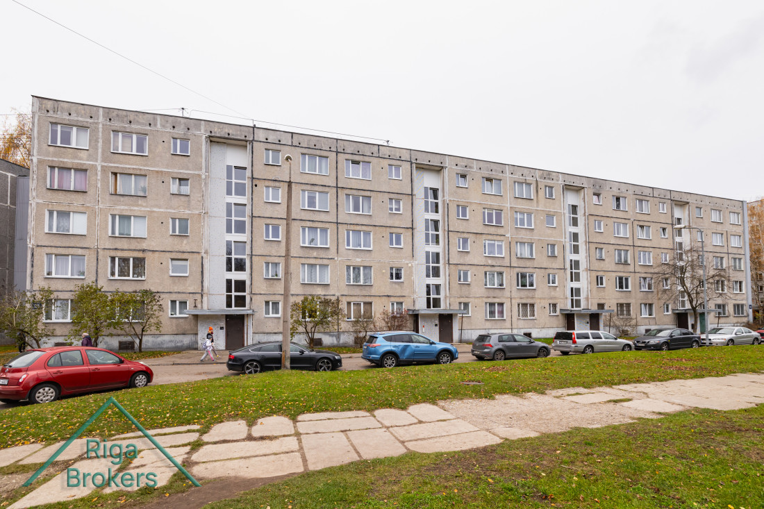 Apartment building facade with parked cars.