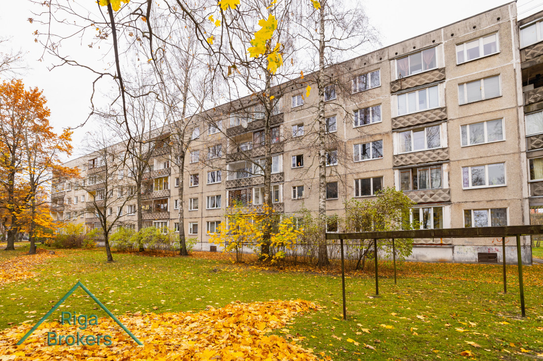 Five-story apartment building in autumn scenery.
