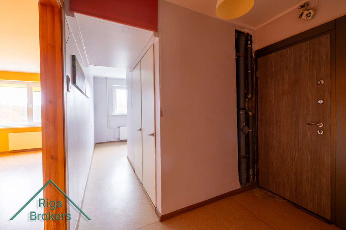 Apartment hallway with light walls and cabinets.
