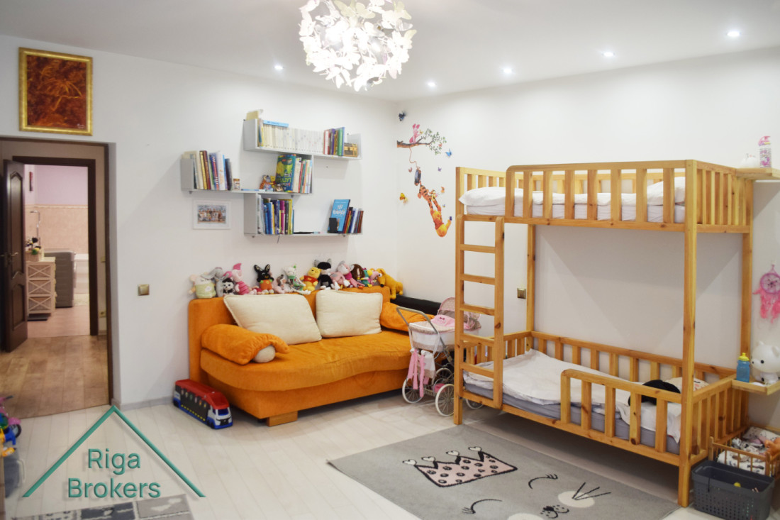 Children's room with bunk bed and orange sofa.