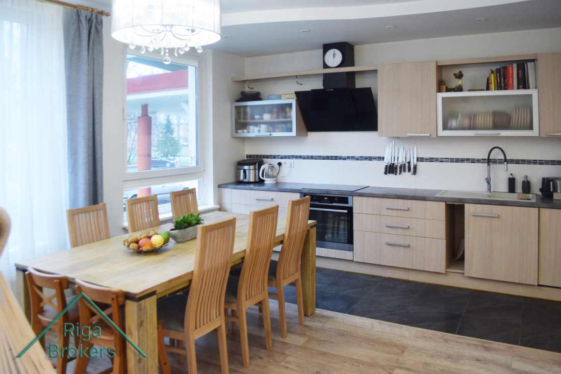 Dining area with wooden table and kitchen cabinet.
