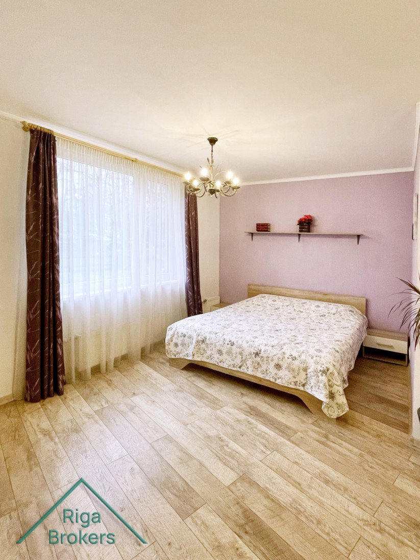 Bedroom with bed by a large window.