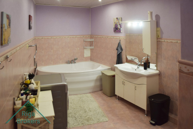 Bathroom with corner bathtub and light design.