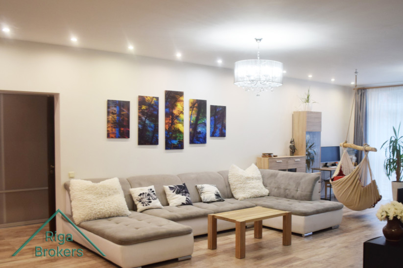 Spacious living room with a painting on the wall.