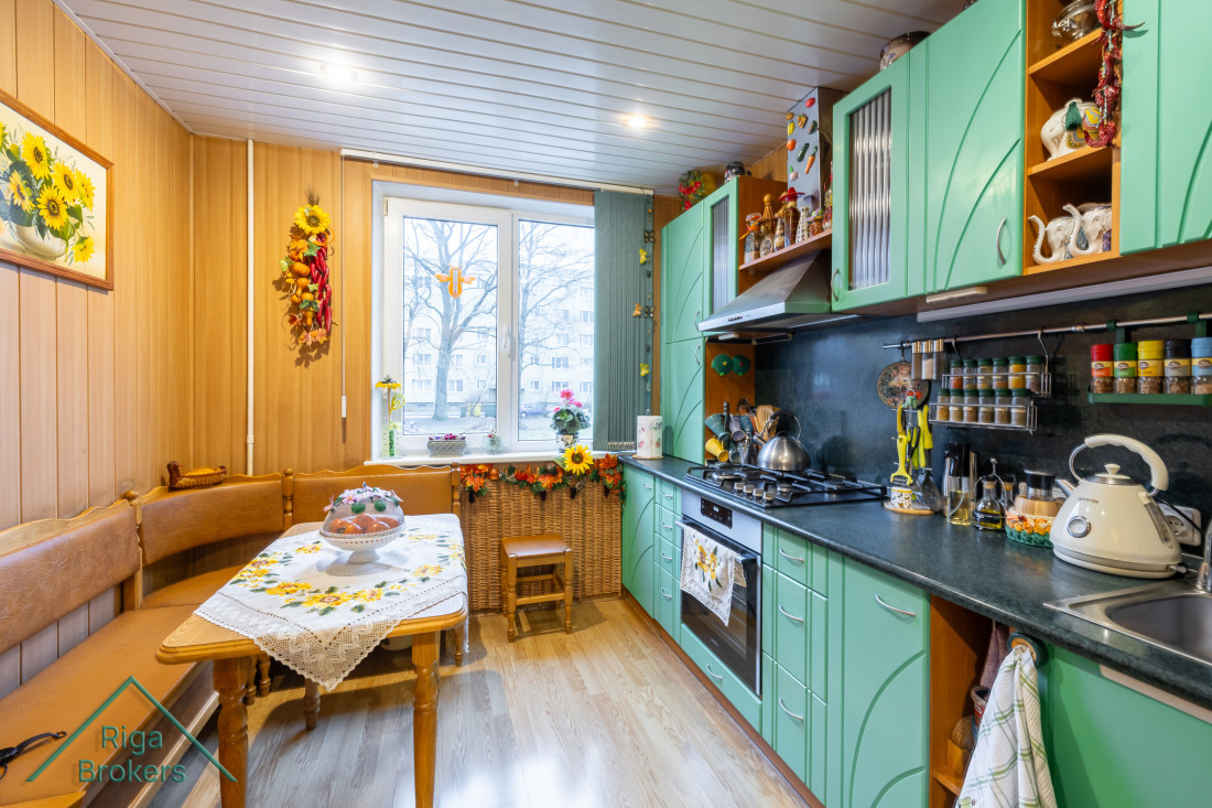 Kitchen with green cabinets and dining table.