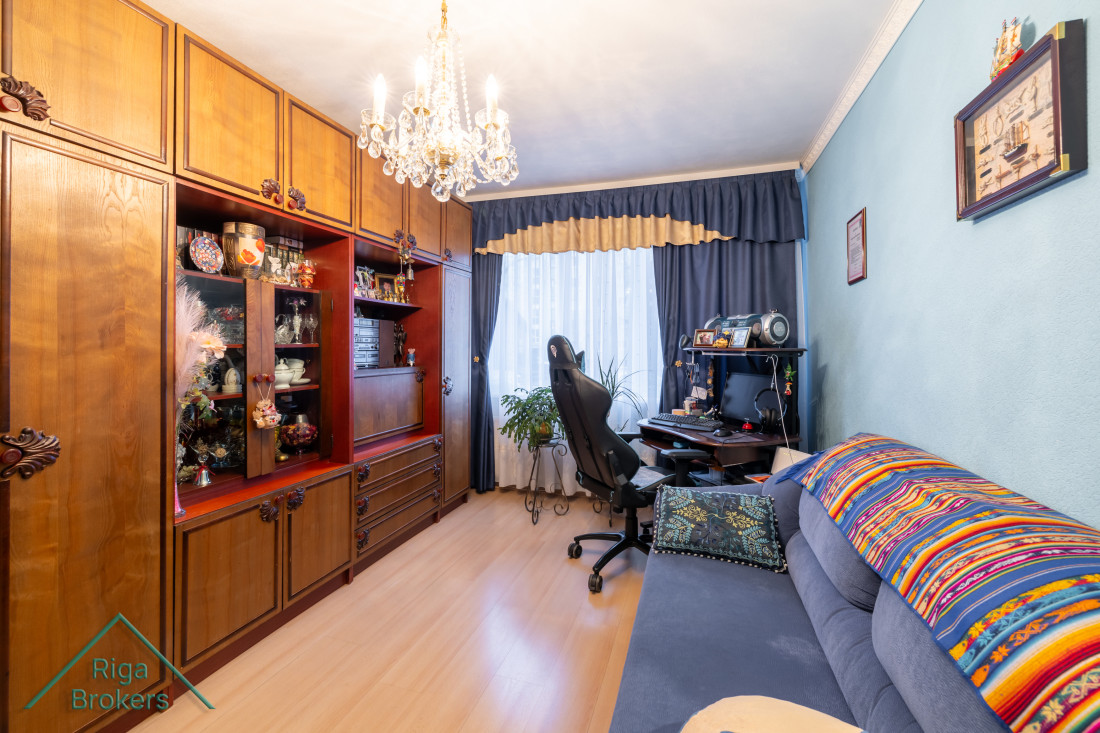 Room with chandelier and desk by the window.