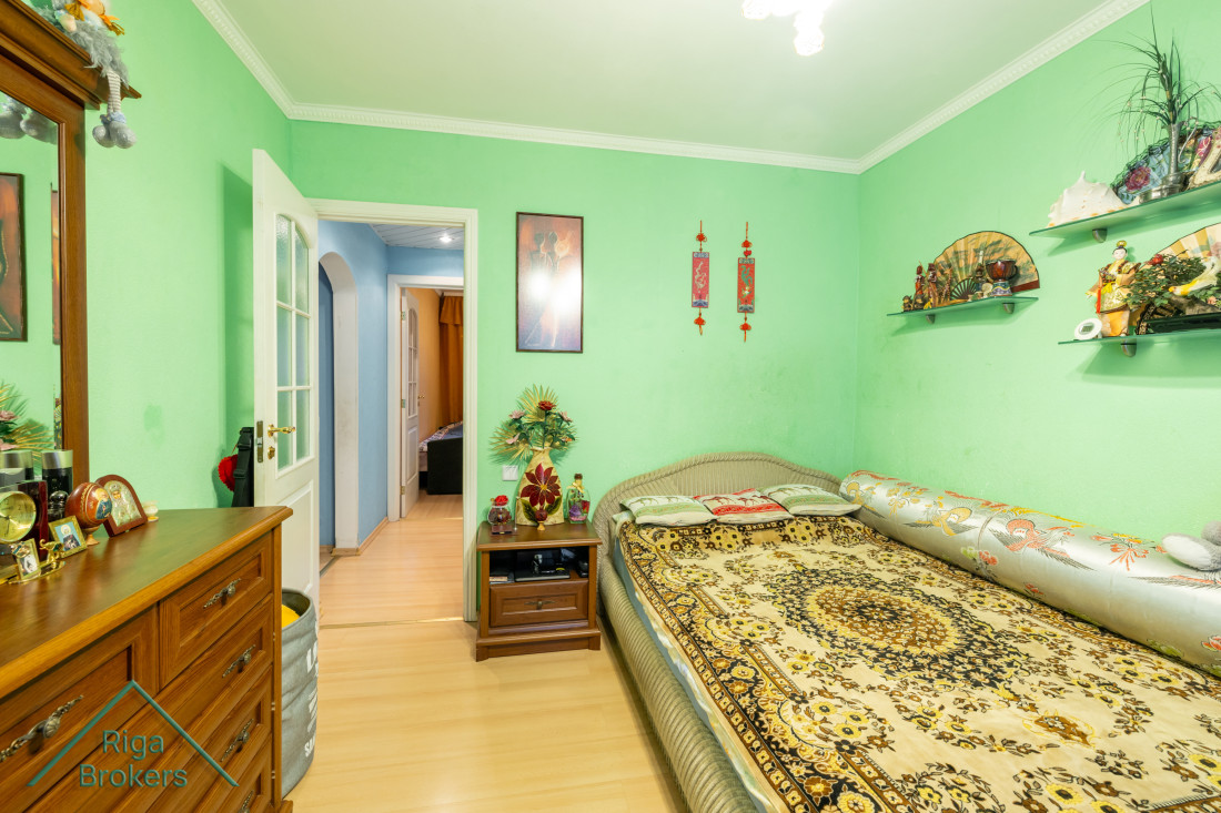 Bedroom with orange curtains and balcony door.