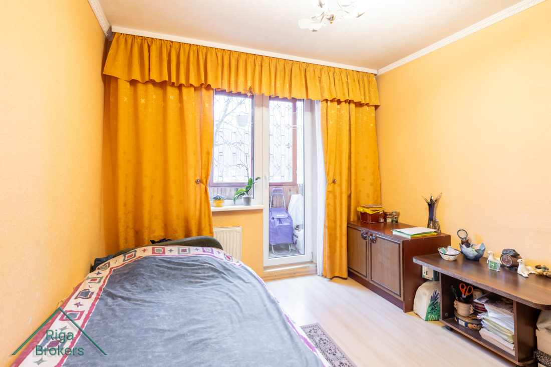 Bedroom with orange curtains and bed.