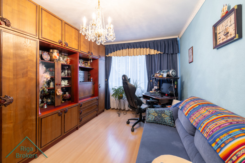 Room with chandelier and desk by the window.